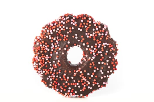 Chocolate covered cookie with pink sprinkles isolated on a white background.