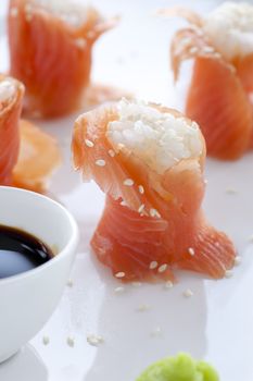Fresh salmon sushi, filled with rice and sprinkled with sesame seeds.