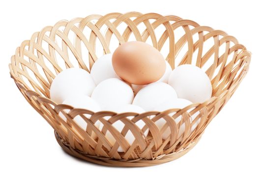 Some white and one brown eggs in a basket over white background