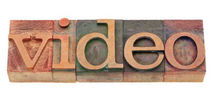 video word in vintage wooden letterpress printing blocks, stained by color inks, isolated on white