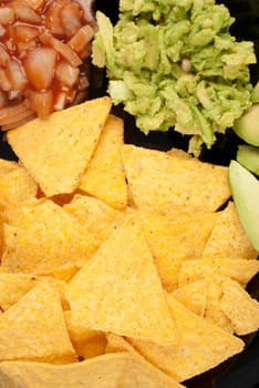 Nacho tortilla chips with dips and avocado