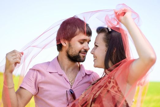 Young happy couple on the field. Shoot on the nature.