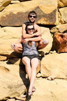 Young happy couple on the rocks. Shoot on the nature.