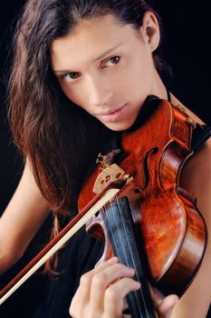 Young woman playing violin. Isolated on the black background