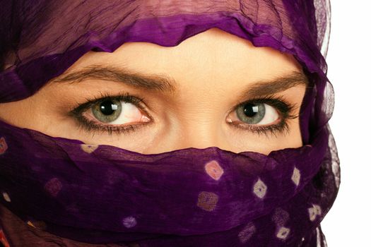 A closeup of a very beautiful Indian or asian woman wearing a purple veil