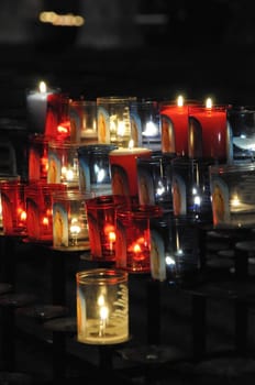 Close-up on some religious candles on a black support in a church