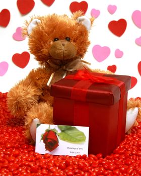 A red gift box and teddy bear to send to someone with love.