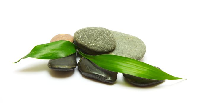 Pile of stones and bamboo leafs isolated on white