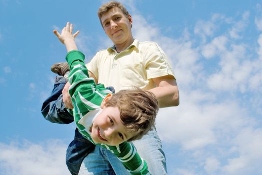 Father and son against the blue sky