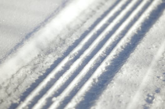 Close-up on a tyre trace in the snow with big cramps