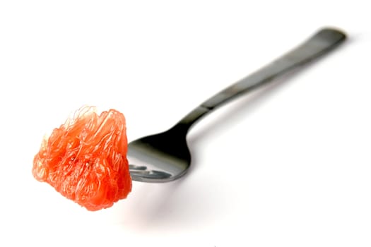 a fork with a piece of grapefruit on a white background