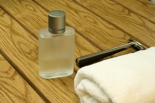 men's perfume in a bathroom with towel and shaver