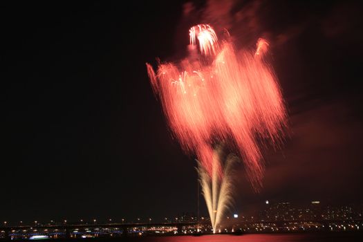 Spectacular Fireworks display with reflection in the water and city as the background