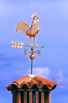 A weathercock indicates wind direction on a chimney pot