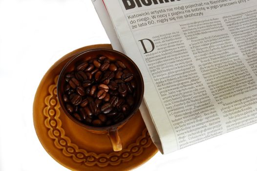 cup with coffee beans and newspaper isolated on the white background