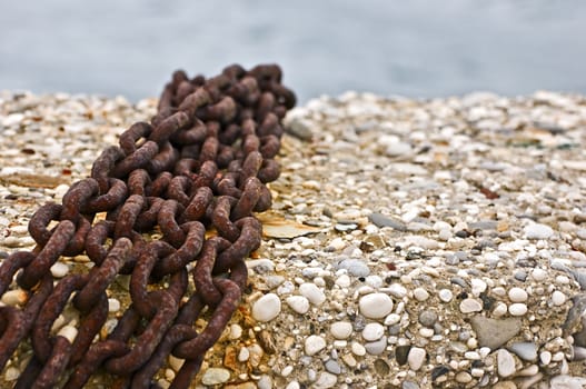 Four rusty chains on a pier