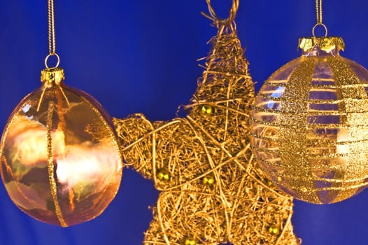 Two decorated christmas balls and a star in background