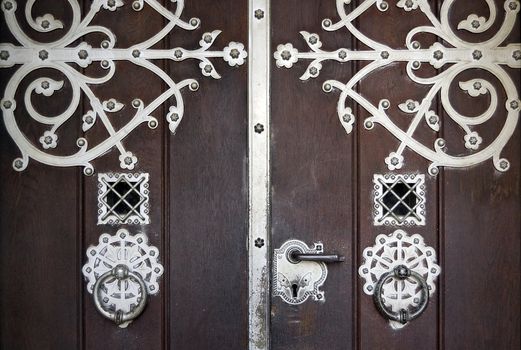 Ancient wooden main entrance with applied metallic decorations