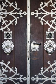 Ancient wooden main entrance with applied metallic decorations