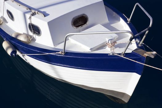 Blue and white little pilot boat with dark background