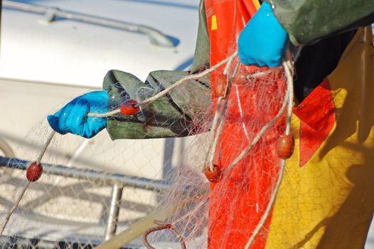 Fisherman on the boat preparing nets for fishing