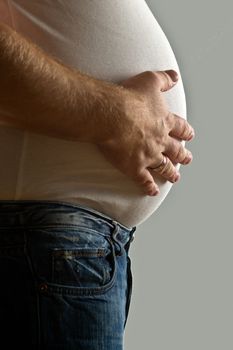 Overweight mid-adult man with hand on belly, mid section