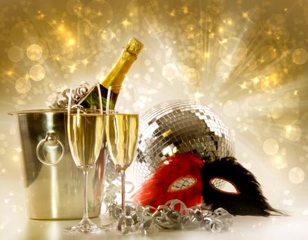Two glasses of champagne and ice bucket against festive gold background