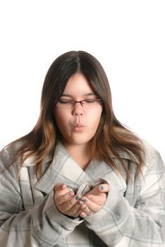 A teenage girl blowing whatever you want out of her hands, isolated against a white background.