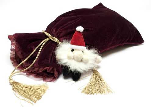 Santa Claus toy and fancy luxury gift bag over white background 