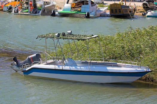 Motorboat with  elevated motor on  water near  boat station.