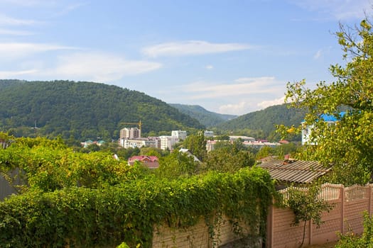 Walls, with ivy, and  village of mountains in  background.