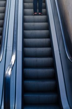 Electric escalators moving up from a dark to clear environment.