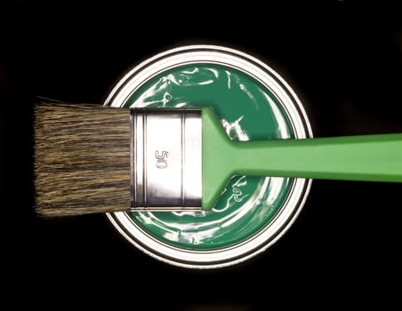Green Paint can and brush from above on black background