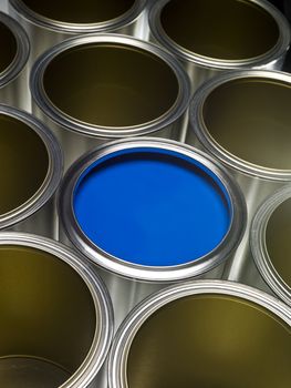 Paint cans full frame with blue paint in one of them