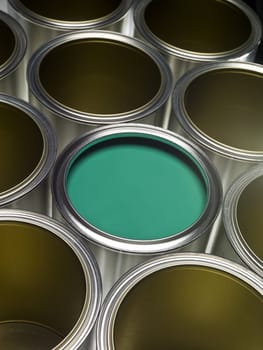 Paint cans full frame with green paint in one of them