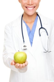 Doctor woman giving / showing apple. Young female medical professional isolated on white background.