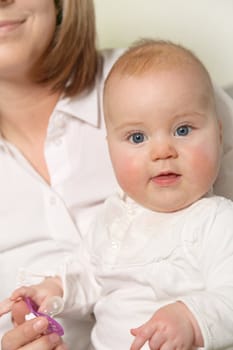 Cute baby in the womb of the mother looking attentively in the direction of the camera. The mother is seen in the background.
