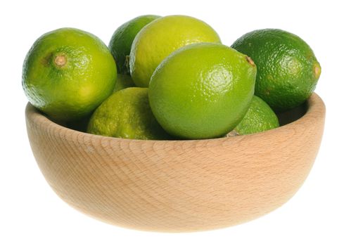Wooden bowl filled with limes isolated on white background