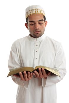 Man wearing cultural clothing is reading or studying a religious holy book.  White background.