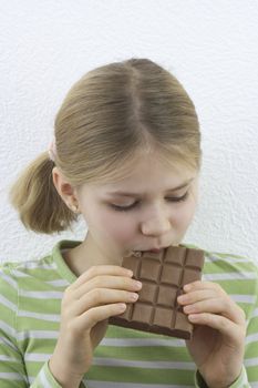 little pretty girl eating big chocolate bar