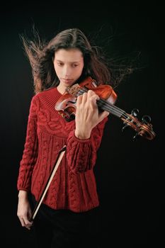 Young woman playing violin. Isolated on the black background