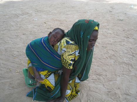 woman carryin a baby in a traditional way in Cameroon