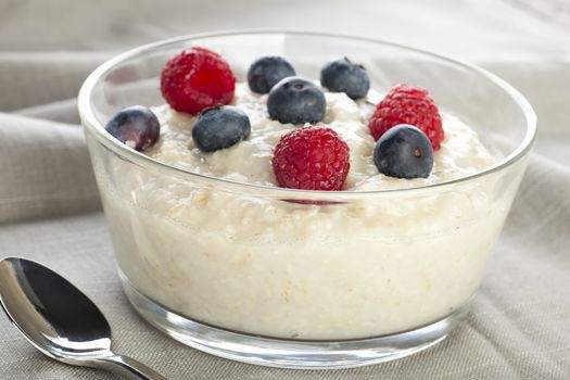 Creamy and healthy oatmeal topped with raspberries and blueberries.