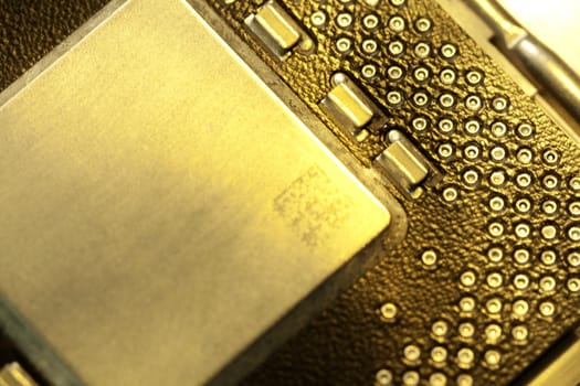Close view detail of a computer microprocessor with a golden light.