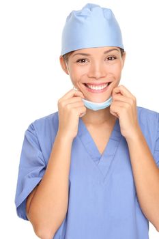 Young female nurse with surgeon mask and scrub smiling happy. Isolated on white background. Mixed race Asian Caucasian female model.