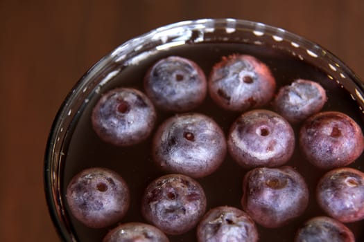 A shot of grape juice with grapes floating in it.
