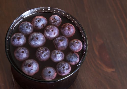 A shot of grape juice with grapes floating in it.
