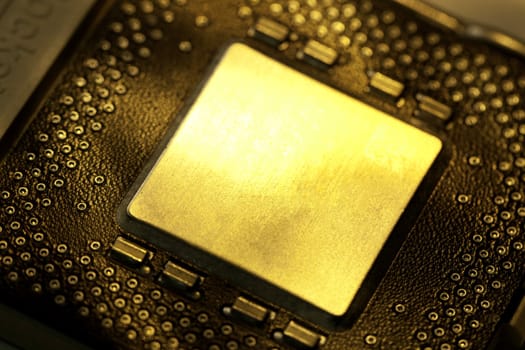 Close view detail of a computer microprocessor with a golden light.