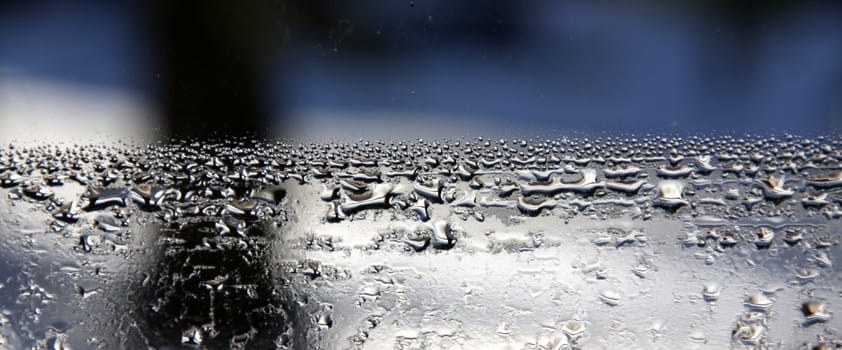 An abstract of water condensation against a blue and black background.