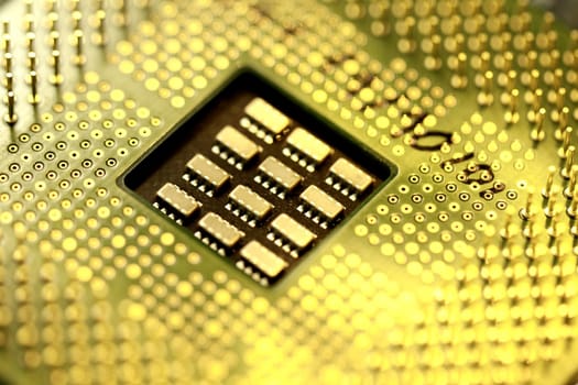 Close view detail of a computer microprocessor with a golden light.